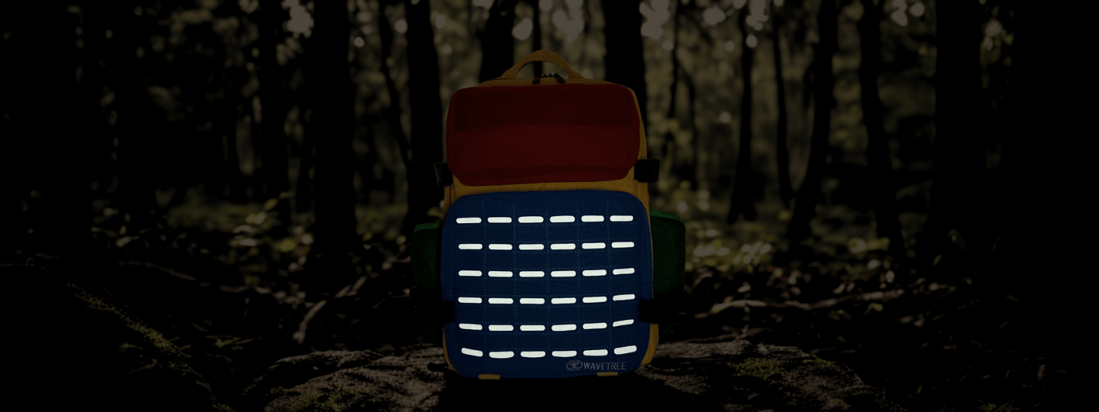Reflective backpack placed on a rock in the forest at dusk