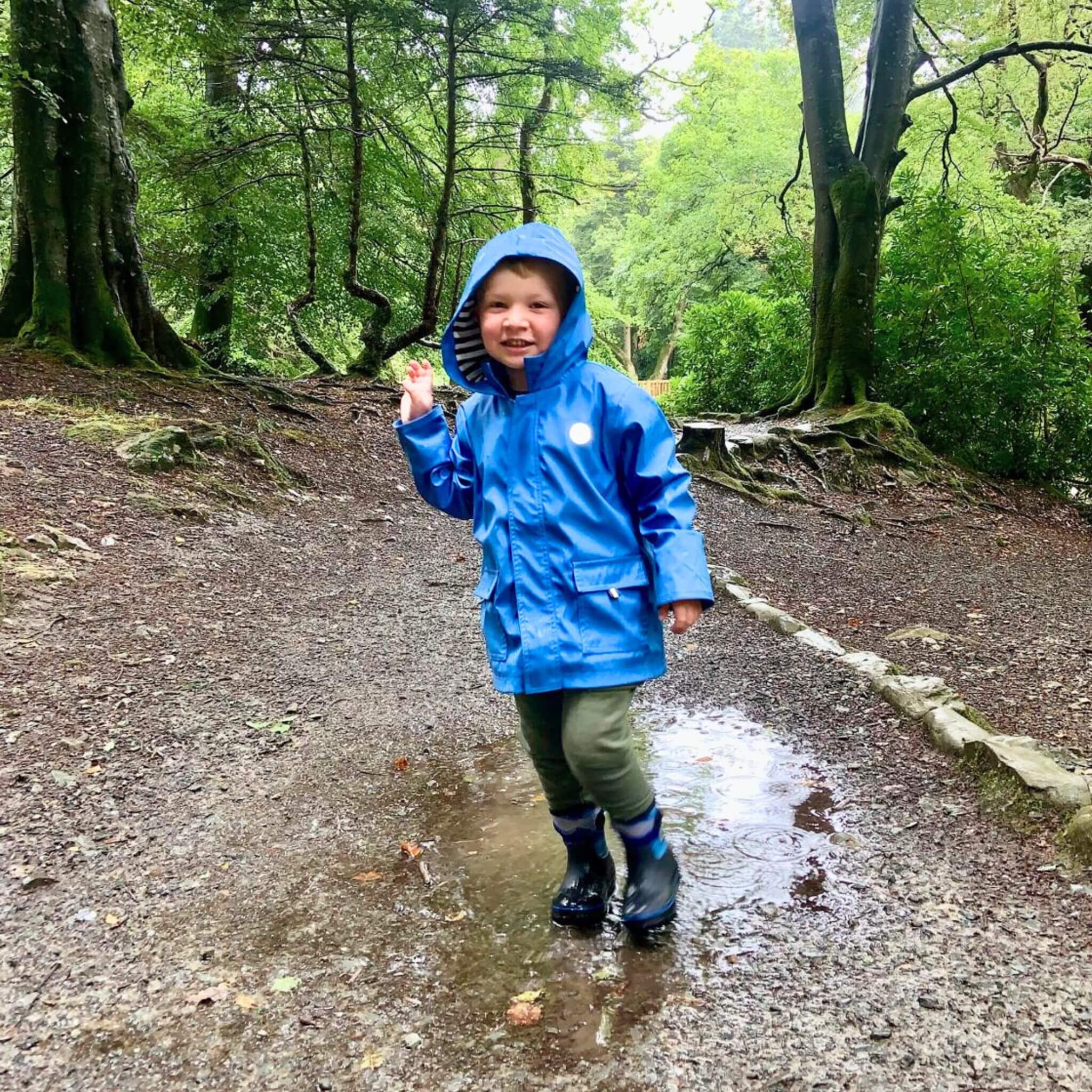 Boy wearing blue raincoat and boots by Wavetree