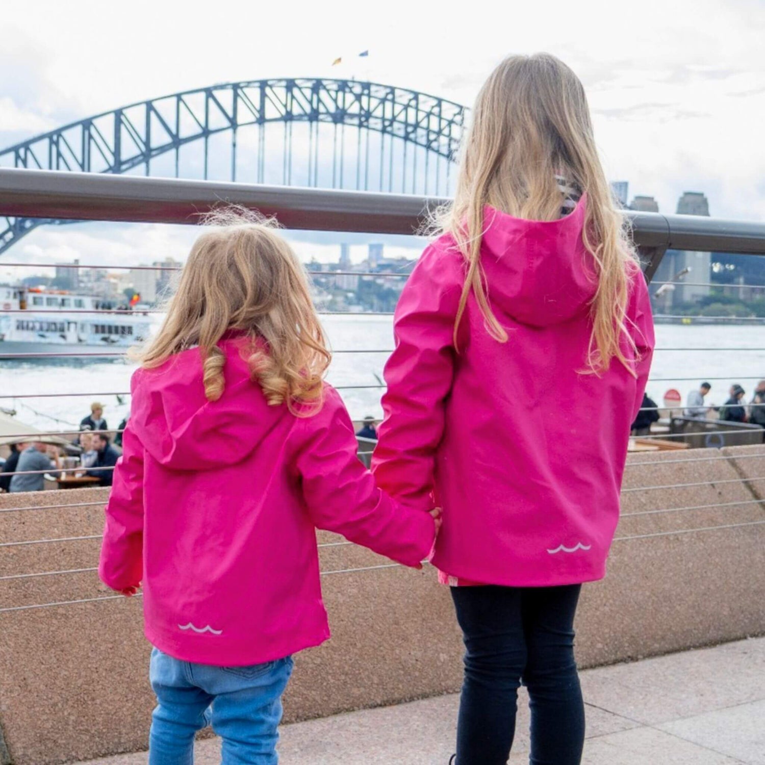 Girls wearing pink jackets looking at Sydney Harbour Bridge