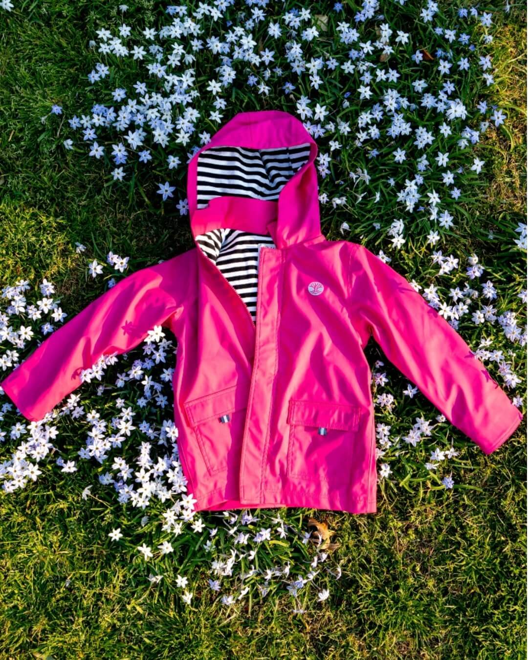 Wavetree Classic Raincoat Pink on grass with flowers